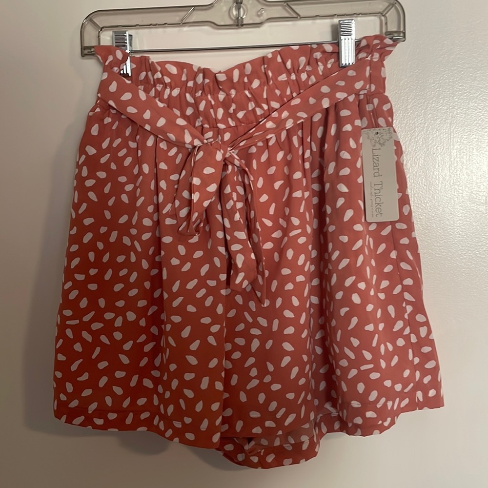 Coral and white spotted paper bag-style shorts.